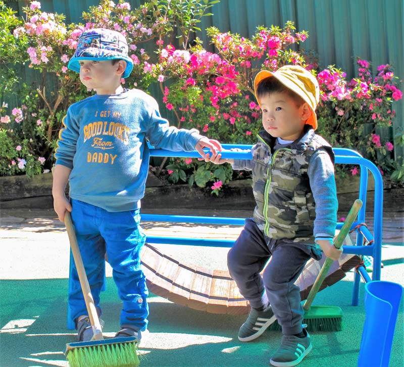 Beverly Montessori kids with brooms